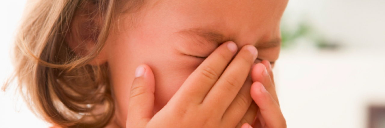 What a Meltdown Feels Like for Someone With Autism Young girl holding her face and crying