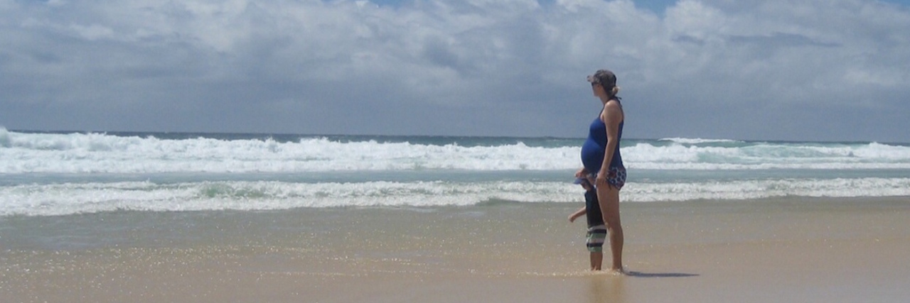 woman and small child standing on beach