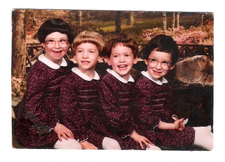 the author and her three young sisters together in matching dresses with a country background