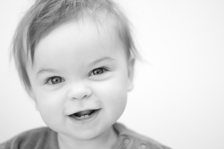 black and white photo of young child smiling at camera