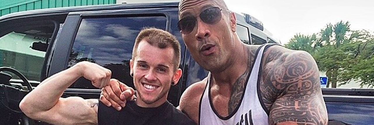 The Rock posing and pointing at fan Nick Miller, who is showing off his own arm muscles