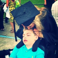 mom kissing son in wheelchair