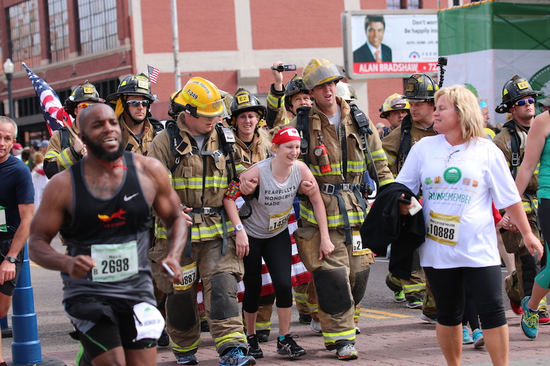 firefighters help kayley cross the finish line