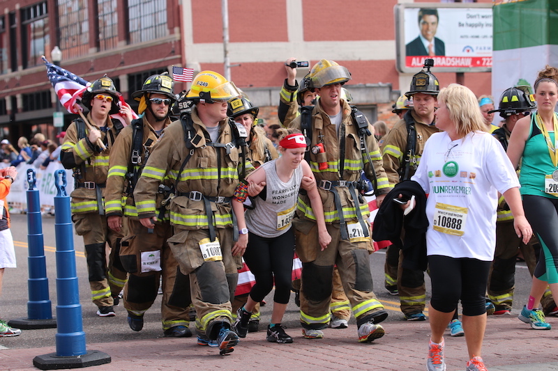 firefighters help kayley cross the finish line