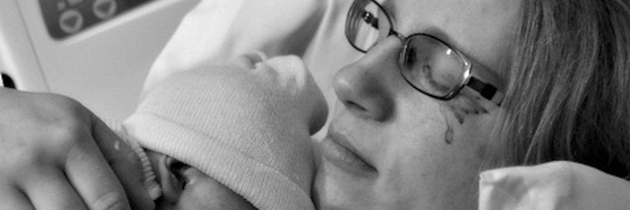 My Postpartum Depression Didn’t Match Any Checklist I Saw mother holding her newborn baby