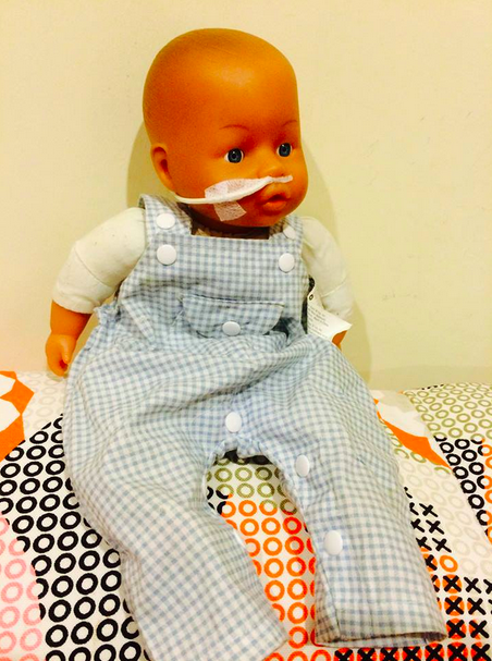 A doll with a nasal feeding tube