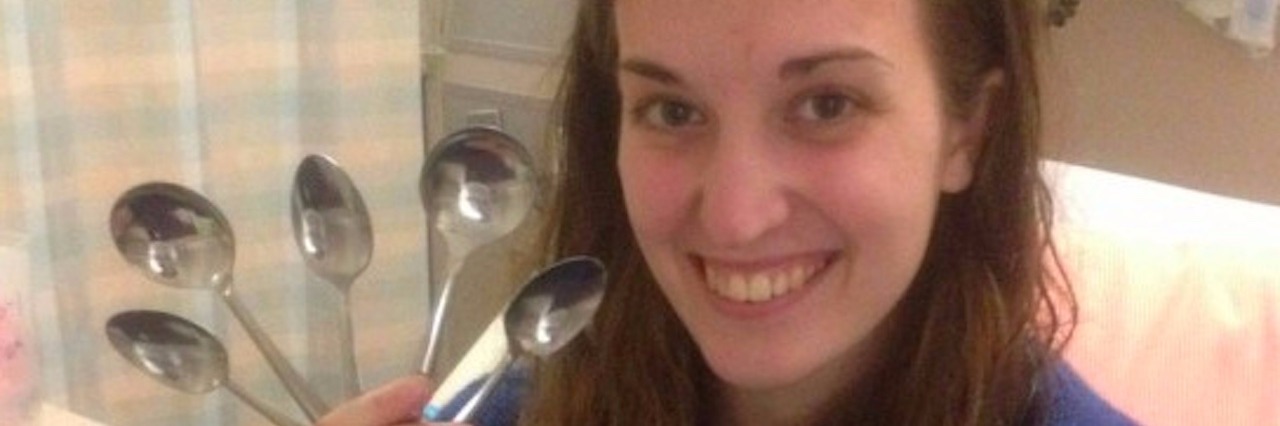 Woman sitting in hospital room, holding spoons