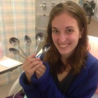 Woman sitting in hospital room, holding spoons