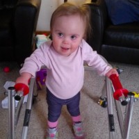 Girl with Down syndrome using a walker to walk