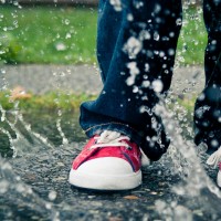 a boys red shoes in a puddle