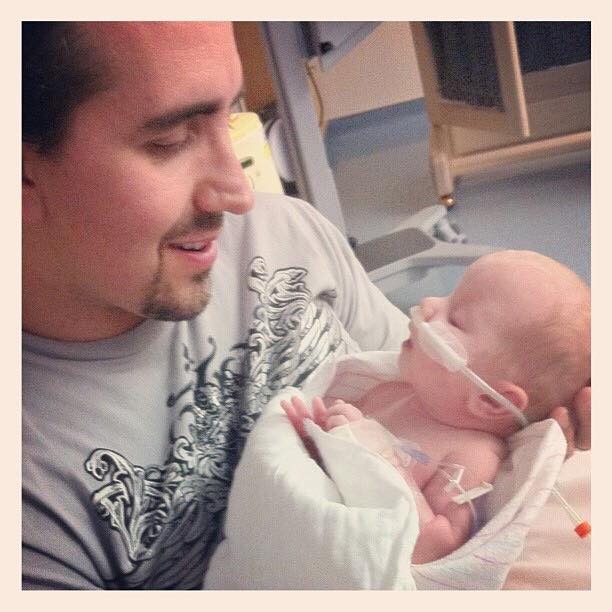 Dad holding and looking down at baby in hospital
