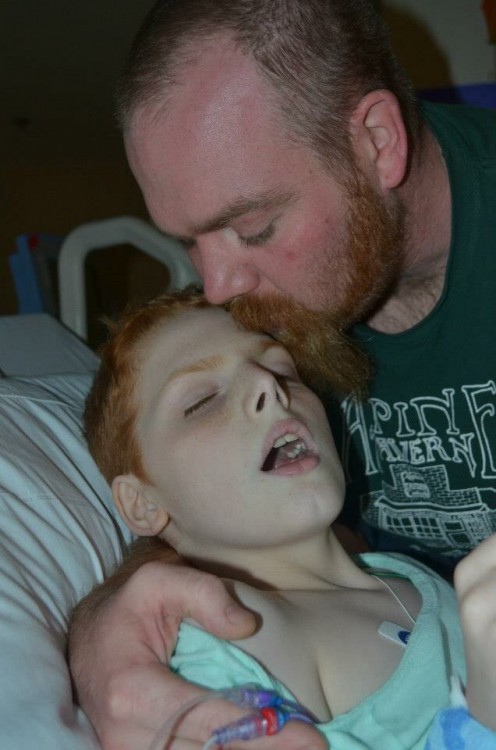Dad kissing forehead of child in hospital