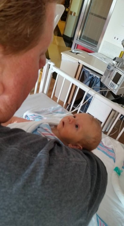 Baby looking up at dad in hospital