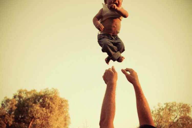 arms throw a baby boy into the air