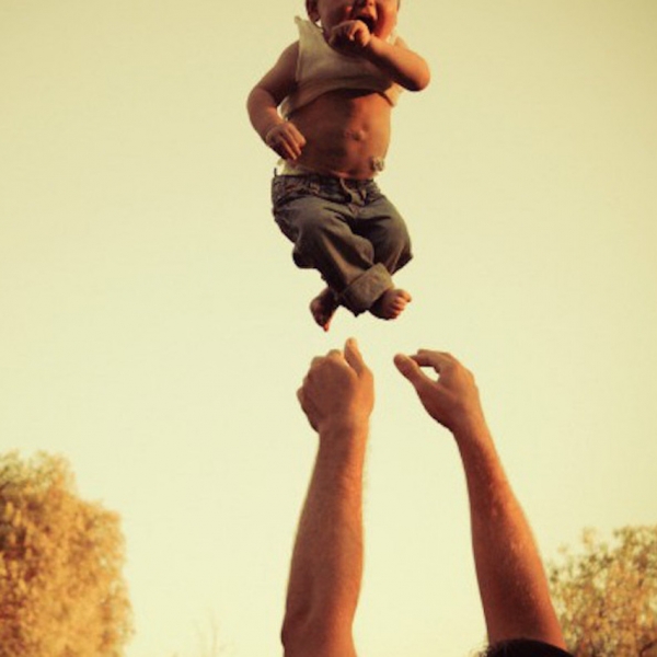 arms throw a baby boy up into the air