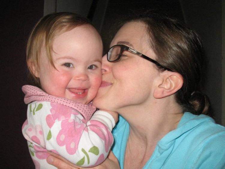 mom kisses her daughter's cheek
