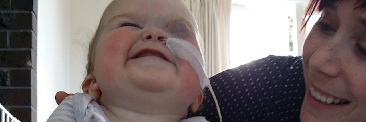 When the Clichés About Child Loss Were True After My Daughter’s Death A mom holds up her blind infant daughter