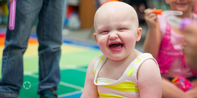 Young girl with a big smile and bald head