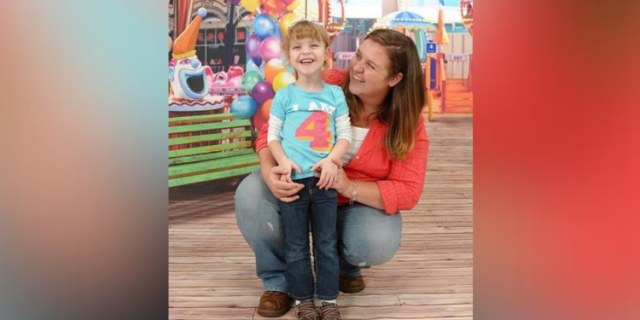 Mother and 4-year-old daughter smiling at a fair