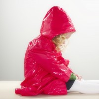 Girls sitting in raincoat, hands on lap