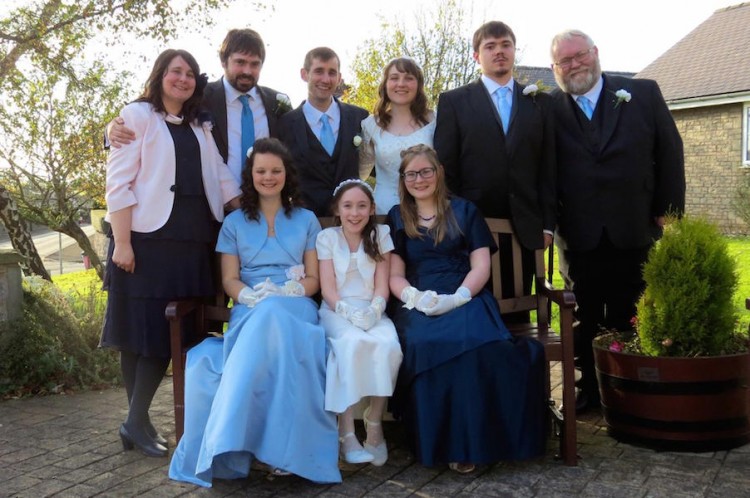 family posing for pictures with bride and groom