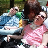 Woman and her daughter and son, who are in wheelchairs.