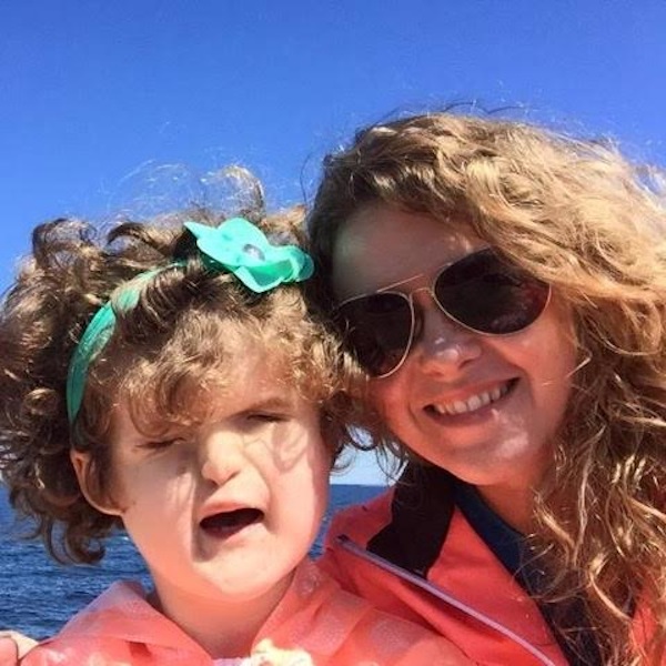 woman and her daughter in lifejackets on the lake