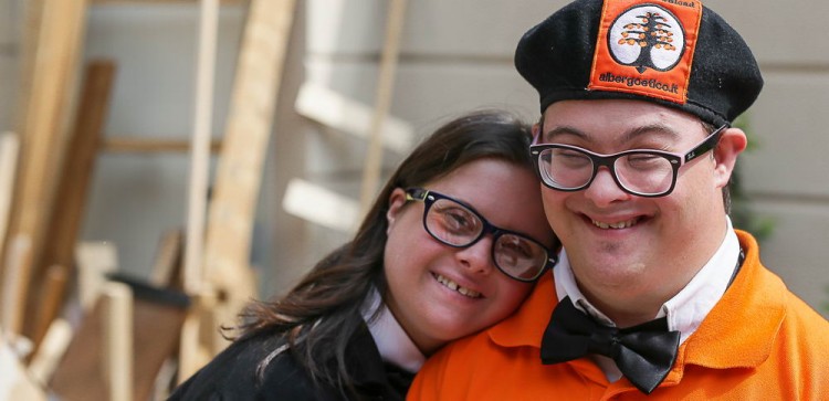 A woman who works at the hotel leans her head on another employee's shoulder. 