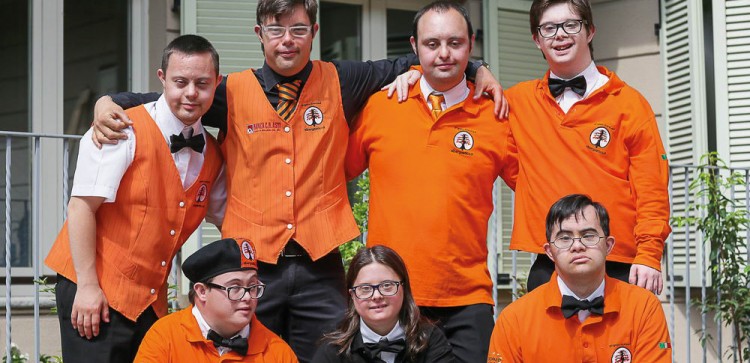 Group photo of the staff, they're all wearing orange uniforms. 