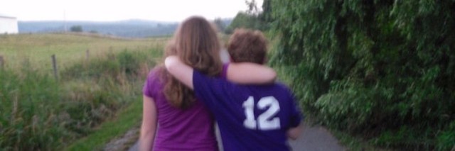sarah schuster walks down a road with her arm around her brother