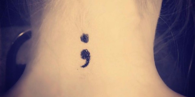 Woman with semicolon tattooed on the back of her neck