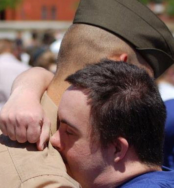 brother with Down syndrome hugging marine