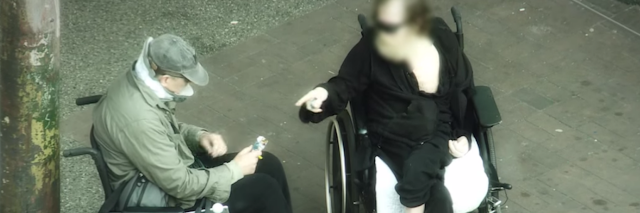 two men in wheelchairs talking