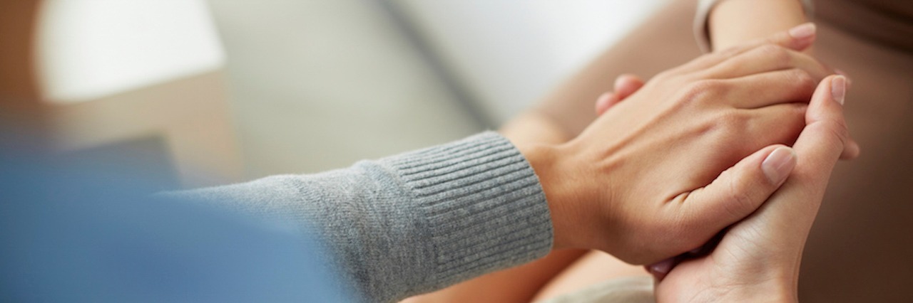 5 Ways to Actually Help Someone Dealing With Loss holding a friend's hands