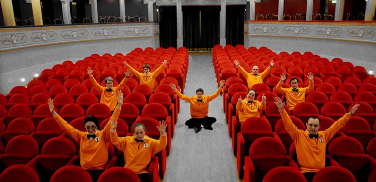 The staff have pose with their hands up in the hotel theater. 