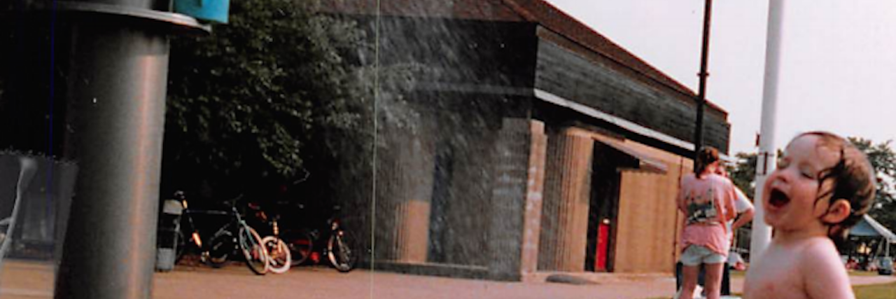 Sensory Overload and Taking Baths young boy playing outside in water