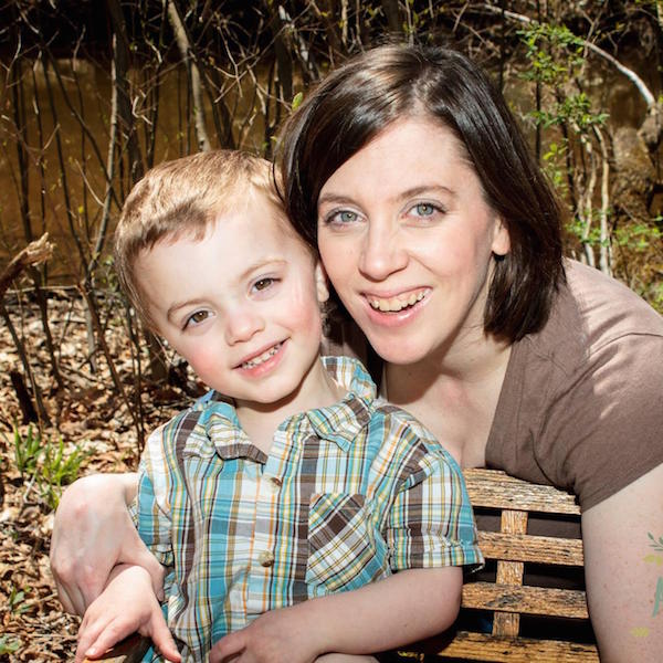 Lori and her son posing near a bench in a park