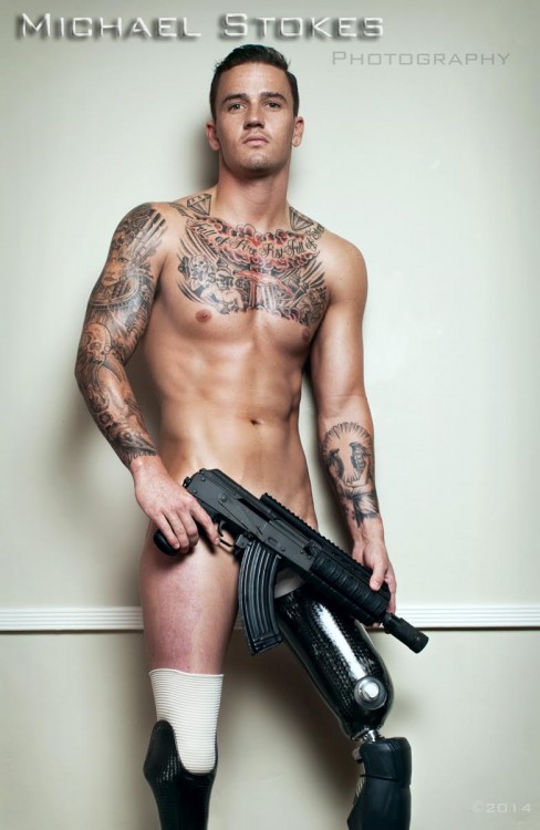 naked man with prosthetic legs, posing with gun