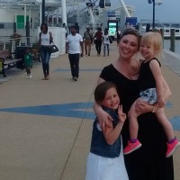 The author and her two children standing on a pier in front of a ferris wheel.