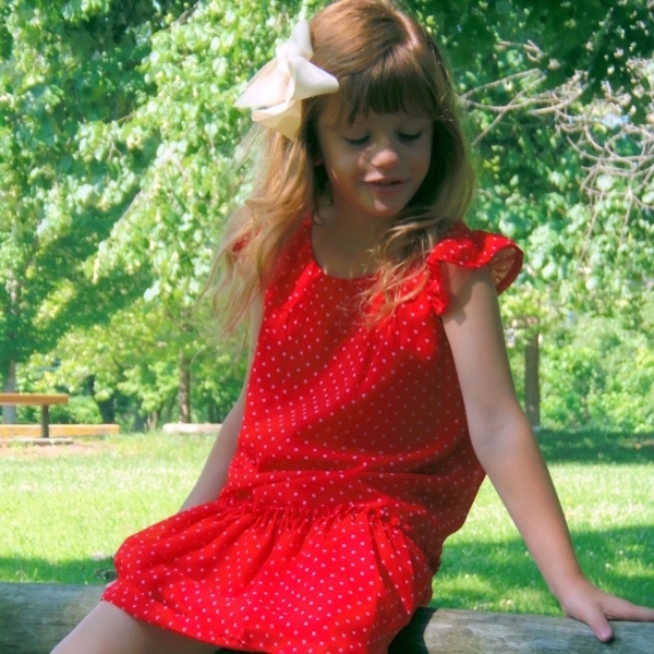 little girl sitting outside in red dress