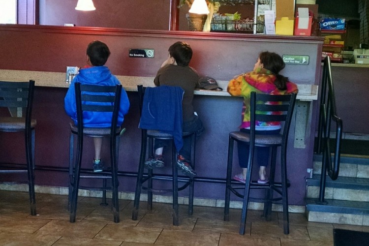 three children sitting in a restaurant