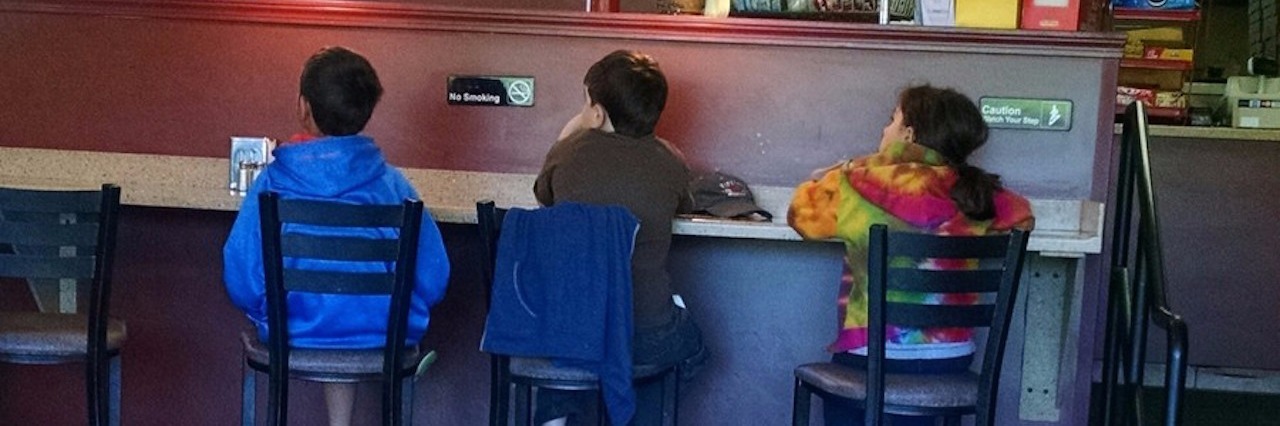 three children sitting in a restaurant