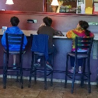 three children sitting in a restaurant