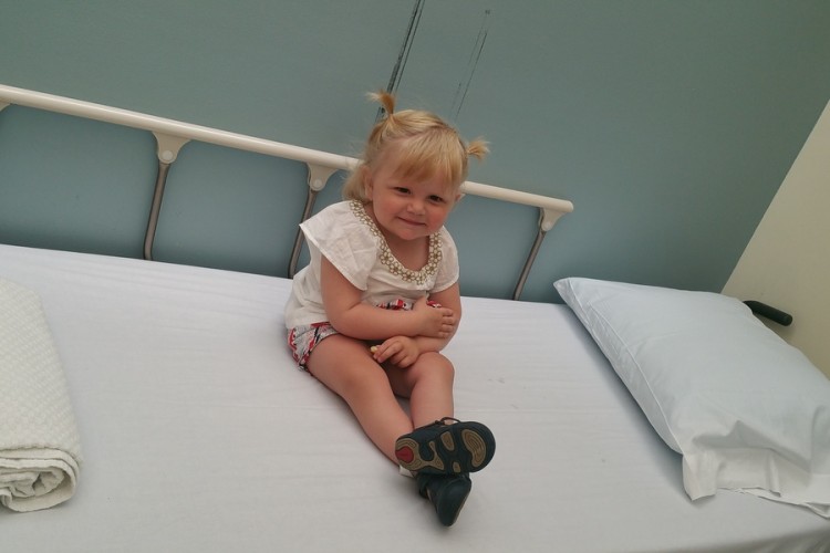 Matt's daughter sitting on a hospital bed