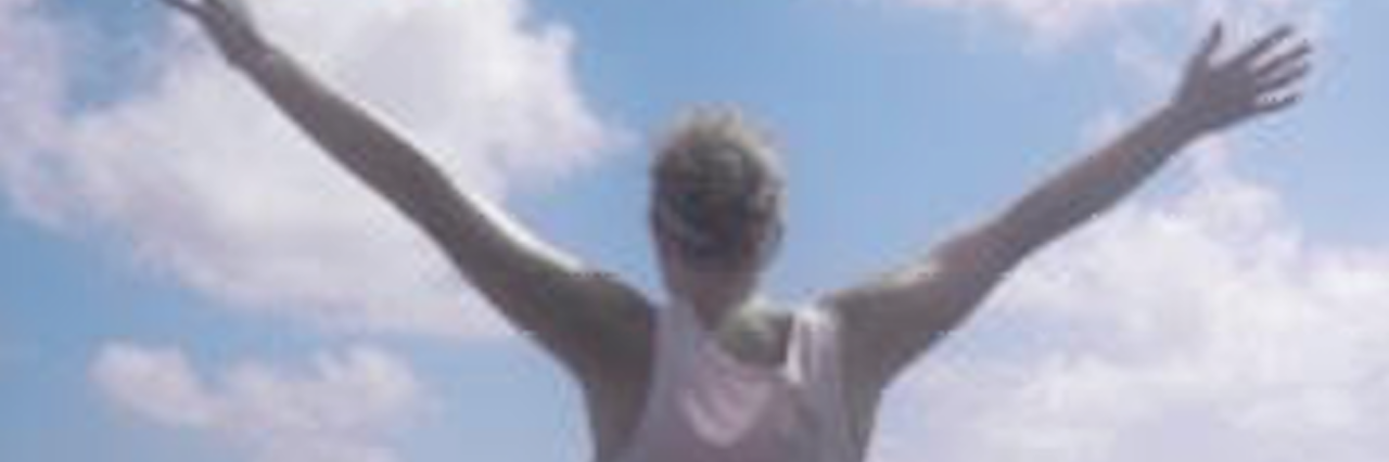 What it Means to Have a Mental Illness woman extends arms in front of the ocean