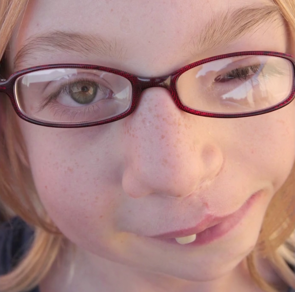 close-up photograph of young girl wearing glasses