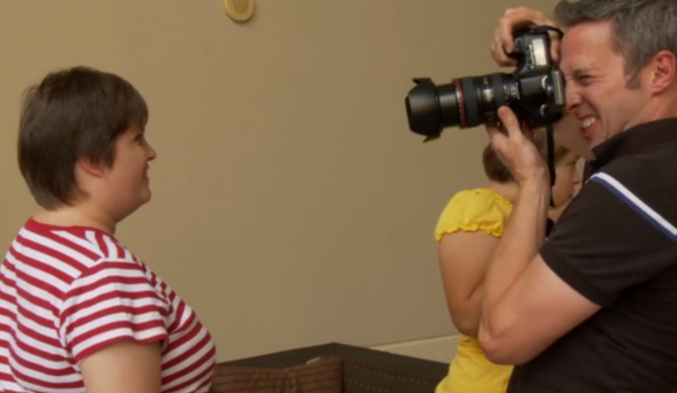 screenshot from film of Guidotti photographing a young woman