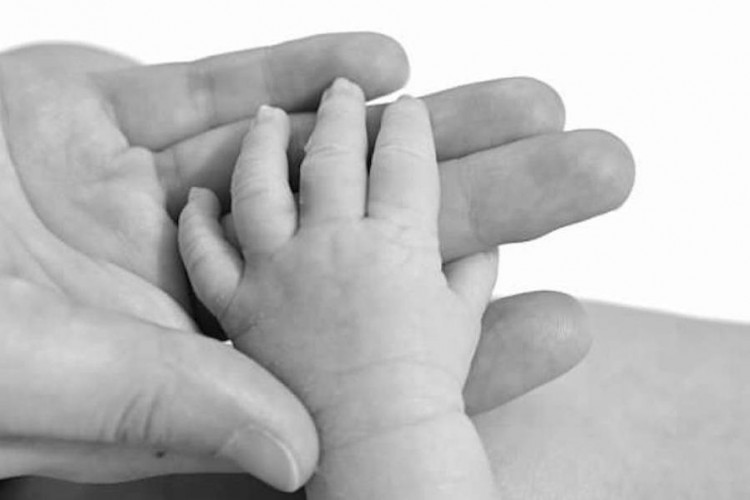 mother's hand holding baby's hand