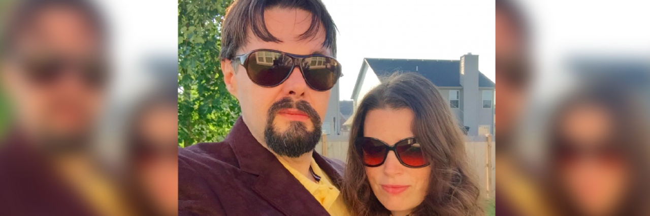 Contributor wearing sunglasses and posing outside with her husband