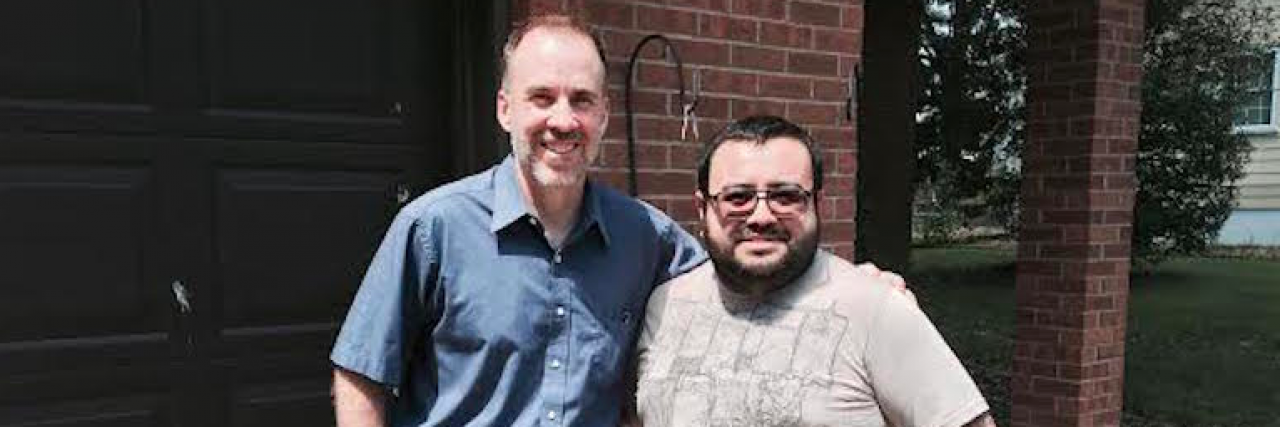 How Opening Up Over a Cup of Coffee Set Me On the Path to Mental Health Recovery Two friends posing for photo with arms around each other in front of a house